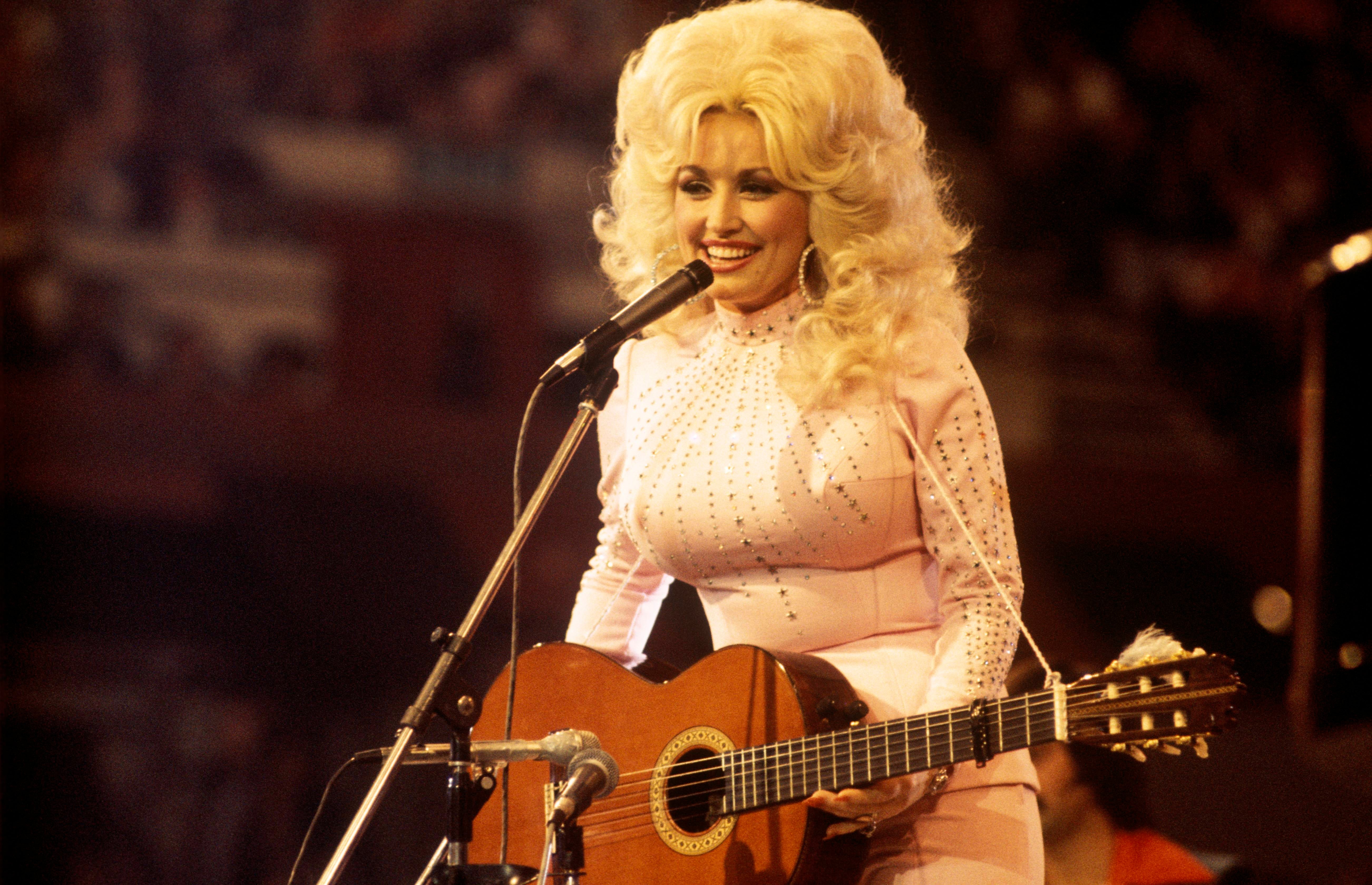 Americká zpěvačka, skladatelka a herečka Dolly Parton při vystoupení ve Velké Británii, 1976 Americká zpěvačka, skladatelka a herečka Dolly Parton při vystoupení ve Velké Británii, 1976