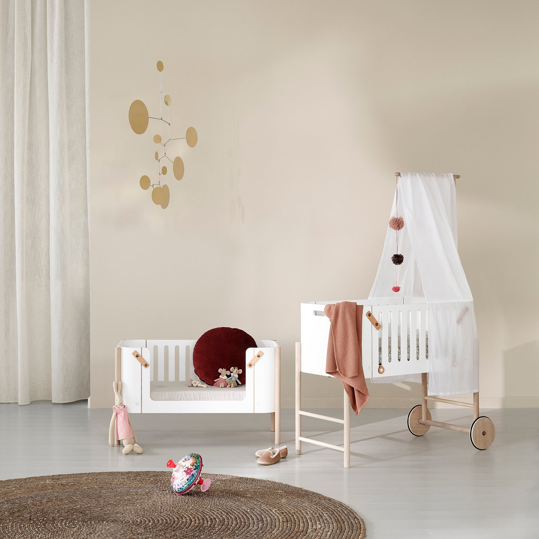 Postýlka pro miminko s kolečky a stejná postýlka přestavěná do podoby malé pohovky.