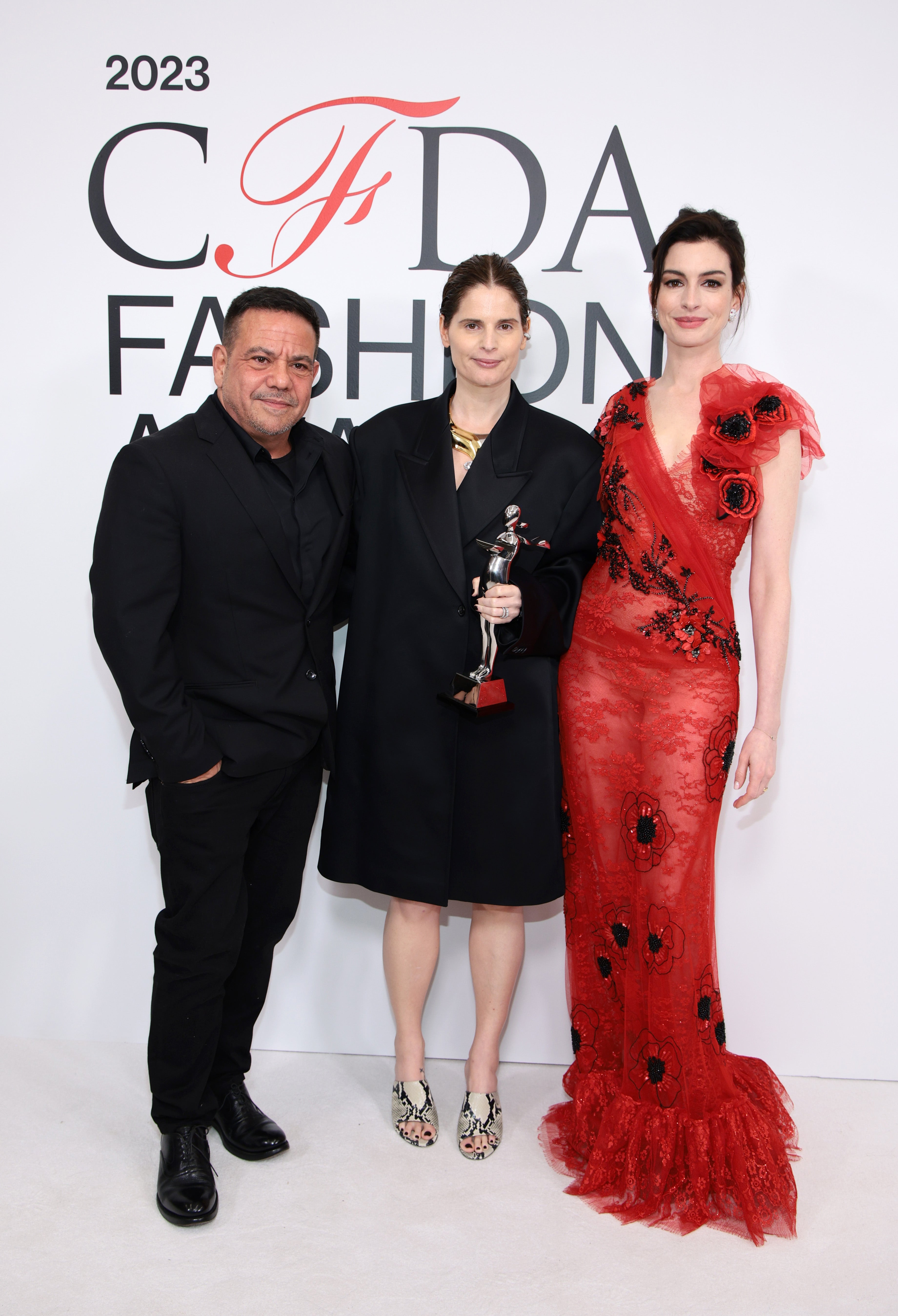 Catherine Holstein, vítězka ceny American Womenswear Designer of the Year (uprostřed), Anne Hathaway (vpravo) a Narciso Rodriguez (vlevo) během 2023 CFDA Fashion Awards v Americkém přírodovědném muzeu v New Yorku, 6. listopadu 2023 Catherine Holstein, vítězka ceny American Womenswear Designer of the Year (uprostřed), Anne Hathaway (vpravo) a Narciso Rodriguez (vlevo) během 2023 CFDA Fashion Awards v Americkém přírodovědném muzeu v New Yorku, 6. listopadu 2023